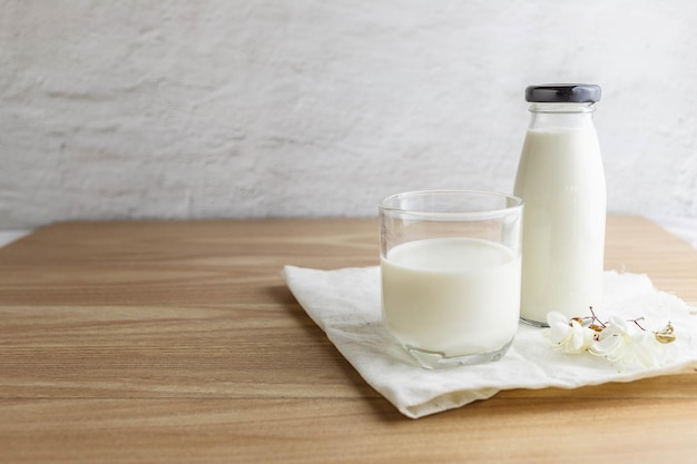 Bouteille de lait et verre de lait sur table en bois