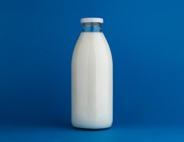 Photo bouteille de lait en verre maquette sur fond bleu