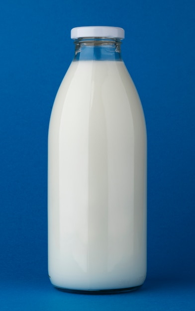 Bouteille de lait en verre maquette sur fond bleu