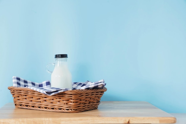 bouteille de lait et un verre sur une table en bois.