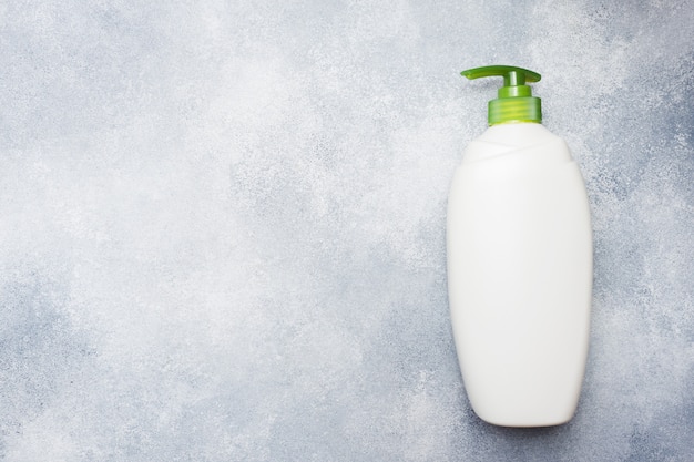 Bouteille de liquide vide blanc sur fond de béton.