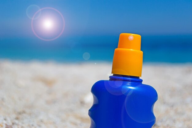 Bouteille de lotion solaire dans le sable