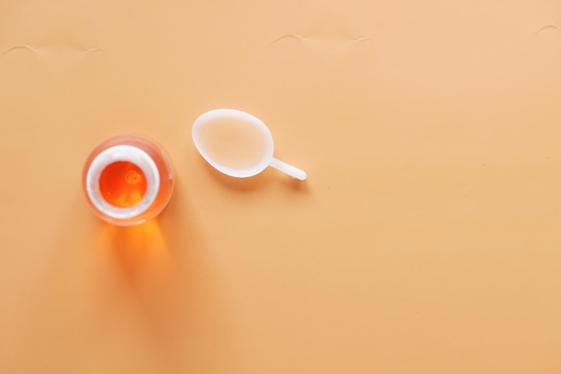 Bouteille avec médicament liquide sur blanc