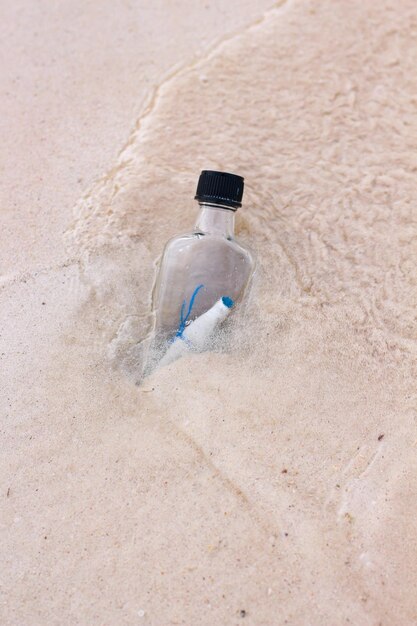 bouteille à message sur la plage balayée par les flots