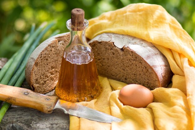 Bouteille de pain frais fait maison avec de l'huile de tournesol et des œufs sur une vieille planche de bois