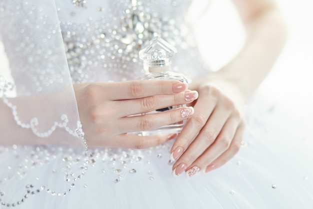 Bouteille de parfum dans les mains de la mariée