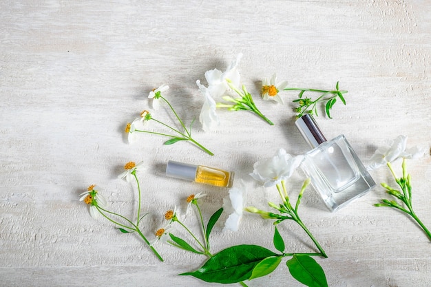 Bouteille de parfum avec des fleurs sur fond blanc