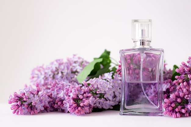 une bouteille de parfum et de lilas sur une surface blanche parfum femme parfum de printemps aromathérapie