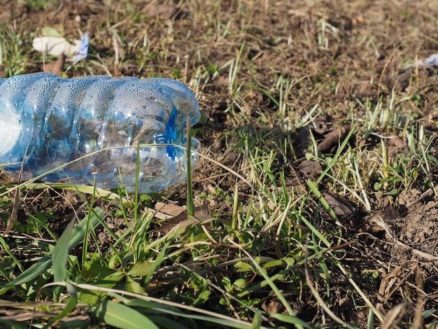 Bouteille en plastique au milieu de l'herbe