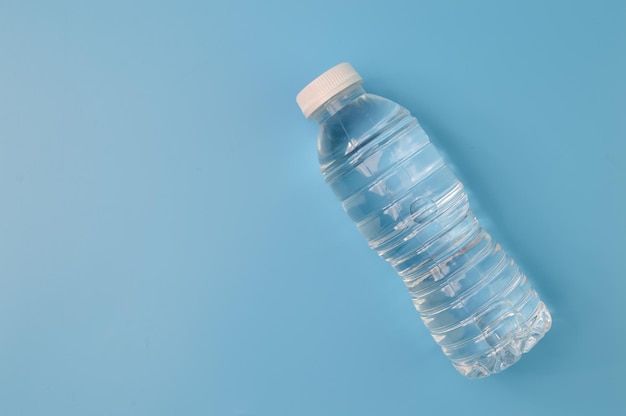 Bouteille en plastique avec de l'eau isolée sur fond bleu