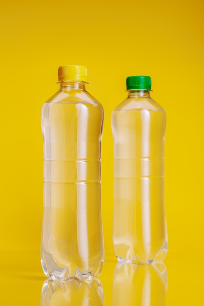 Bouteille en plastique d'eau minérale sur fond jaune vif