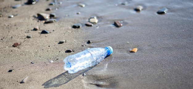 Bouteille en plastique sur la plage de sable