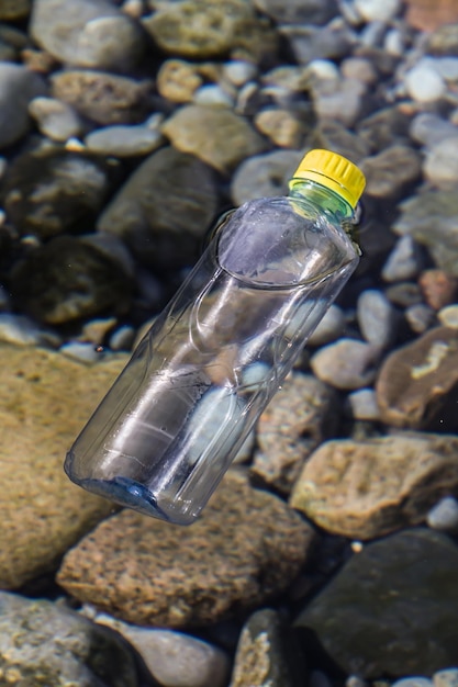 Bouteille en plastique transparente dans l'eau claire d'une source dans la natureSainte source