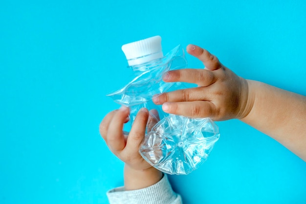 Bouteille en plastique transparente sur fond bleu solide pour recycler les déchets Concept de séparation des déchetsProtéger l'environnement Traitement des ordures Préserver la nature Mise au point sélective