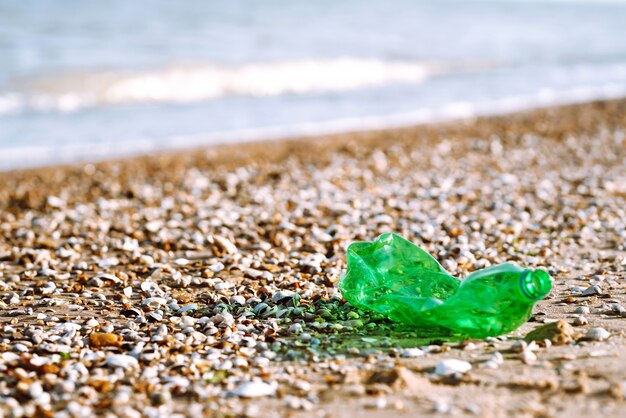 Bouteille en plastique vide sur la plage de la mer. Concept de pollution de l'eau et de la mer.