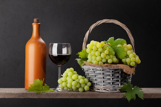 Bouteille de raisin blanc et verre de vin rouge