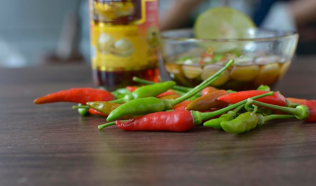 Une bouteille de sauce jalapeno est posée sur une table à côté d'une bouteille de jalapeno.