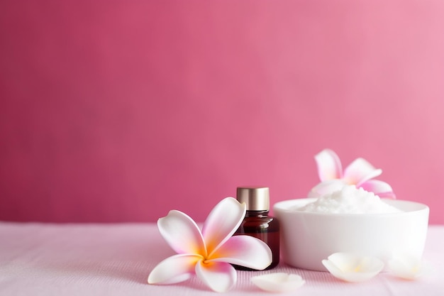 Une bouteille de sel de mer blanc à côté d'un bol blanc avec des fleurs sur fond rose