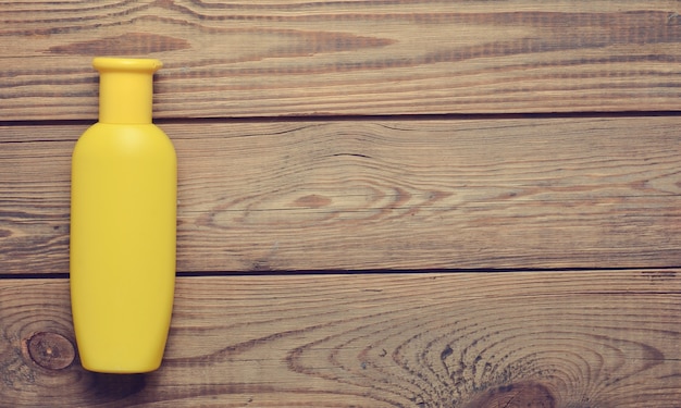 Bouteille de shampoing jaune sur une table en bois