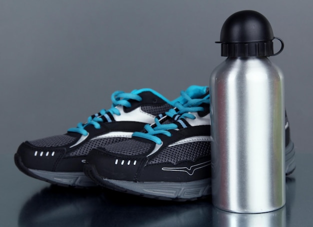 Bouteille de sport et baskets sur fond gris