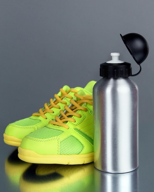 Bouteille de sport et baskets sur fond gris