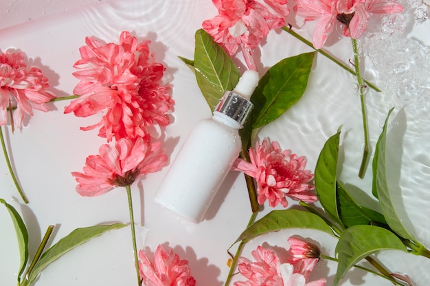Bouteille de tube de maquette pour les cosmétiques de soins de la peau avec des éclaboussures d'eau et un traitement de lotion de crème compte-gouttes de marque de produit de fleur