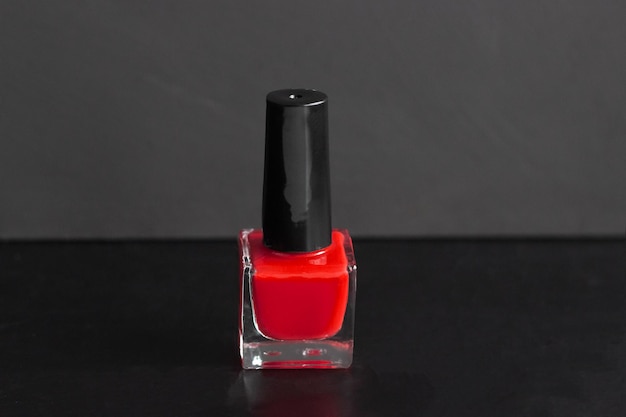 Bouteille de vernis à ongles rouge sur fond noir