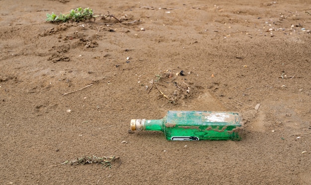 Bouteille en verre abandonnée sur le rivage