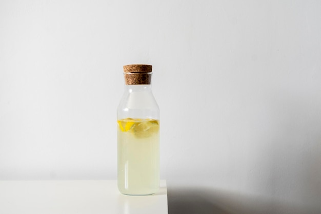 Une bouteille en verre avec du citron frais d'été froid