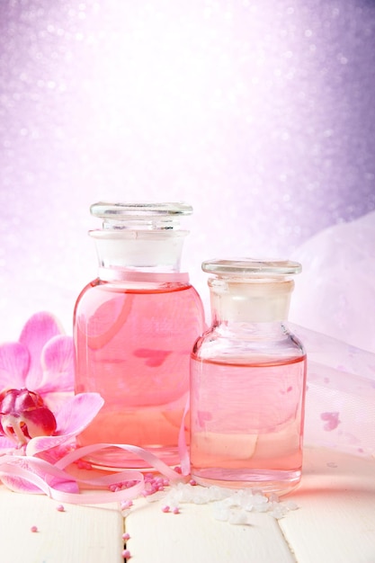 Bouteille en verre avec essence de couleur sur fond rose