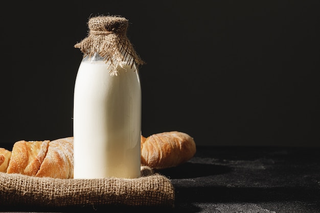 Bouteille en verre de lait avec du pain baguette tranché