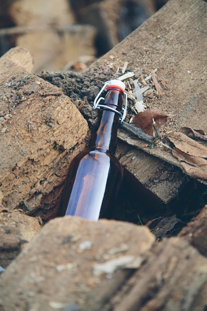 Bouteille en verre sur pile en bois