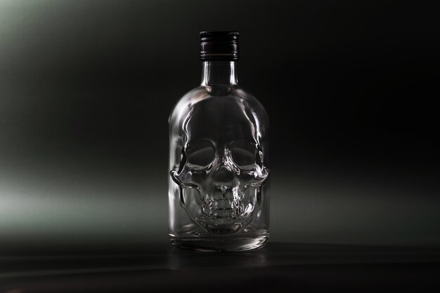 bouteille en verre vide en forme de crâne humain