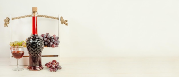 Bouteille et verre de vin rouge sur un fond en bois blanc avec espace de copie