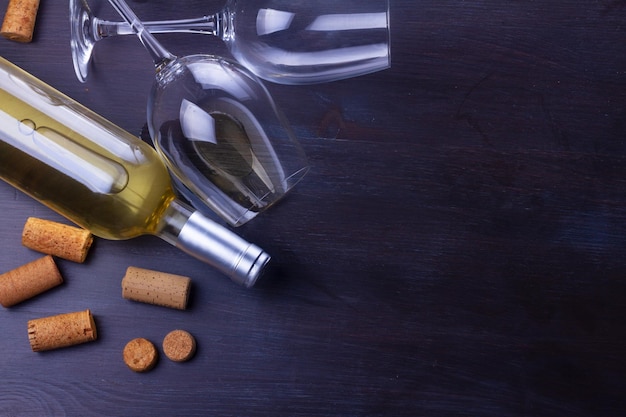 Bouteille de vin blanc et deux verres de vin sur une table plate.