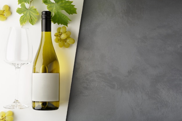Photo bouteille de vin blanc avec étiquette. verre de vin et raisin. maquette de bouteille de vin.