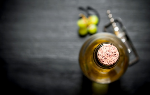 Bouteille de vin blanc sur fond de bois noir