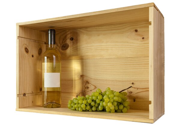 Une bouteille de vin blanc et de raisins blancs dans une boîte en bois avec espace de copie