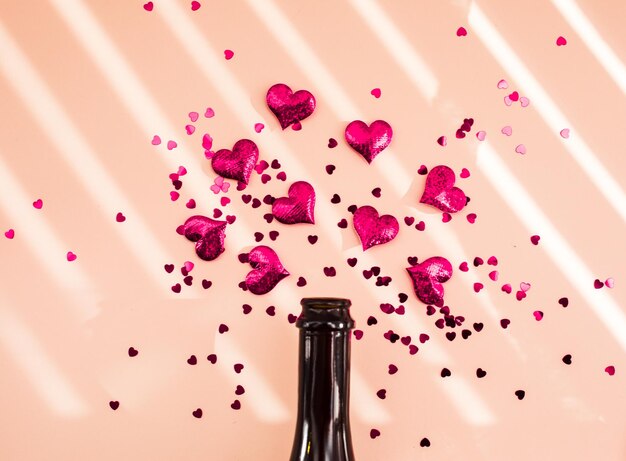 Bouteille de vin et coeurs roses sur superposition d'ombre du matin Concept de début de la Saint-Valentin
