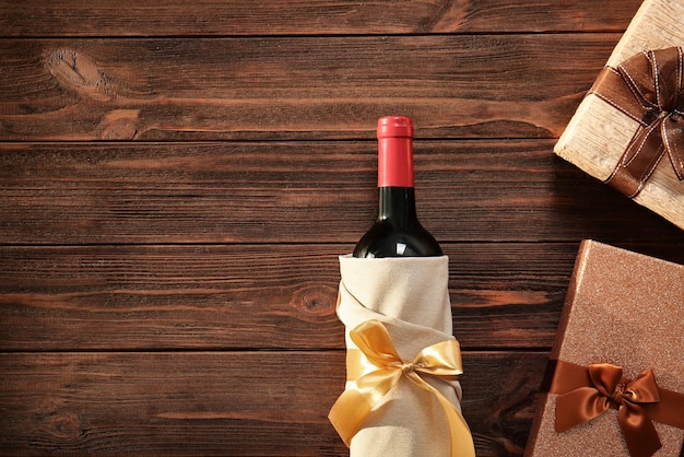 Bouteille de vin décorée et coffrets cadeaux sur fond de bois