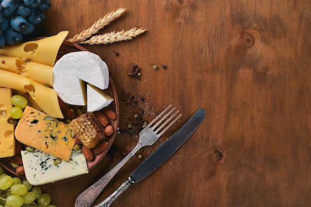 Une bouteille de vin et un grand assortiment de fromages miel noix et épices sur une table en bois Vue de dessus Espace libre pour le texte