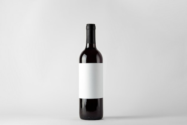 Photo bouteille de vin noir avec du vin rouge isolé sur blanc