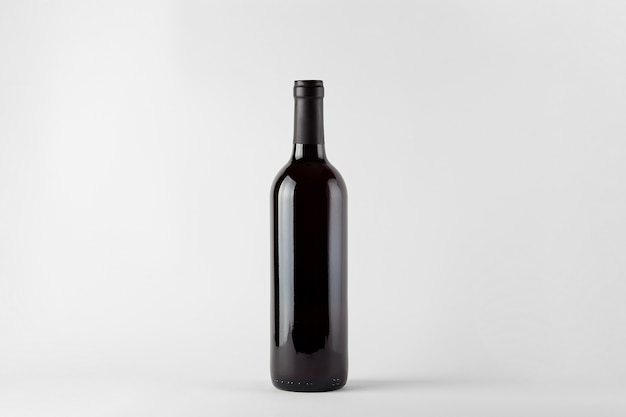 Bouteille de vin noir avec du vin rouge isolé sur blanc