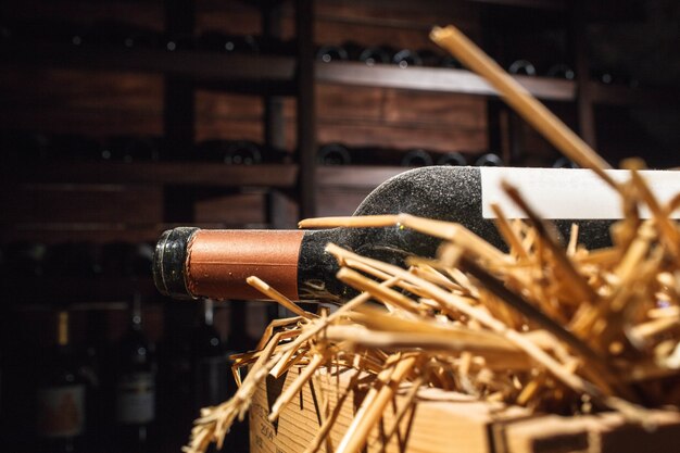 Photo une bouteille de vin ouverte couverte de poussière repose sur le foin