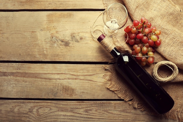 Bouteille de vin et de raisin sur table en bois