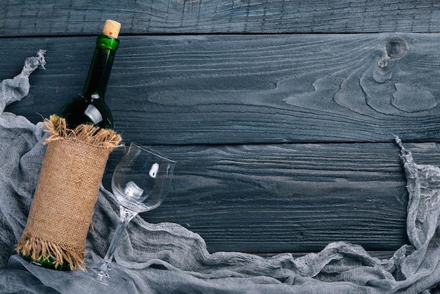 Une bouteille de vin et des raisins. Sur un fond en bois. Vue de dessus. Espace libre pour votre texte.