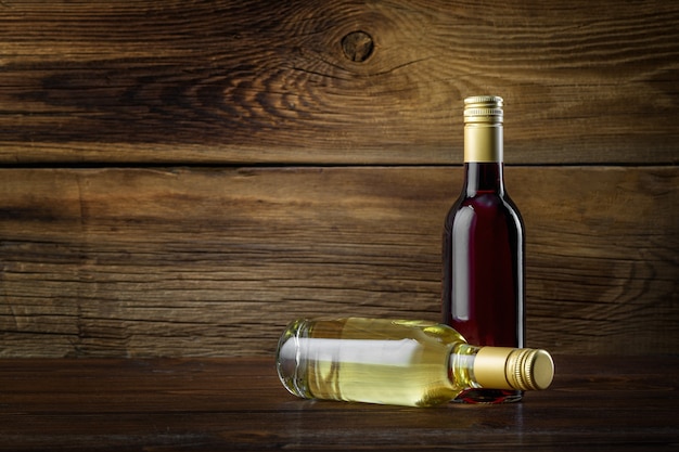 Une bouteille de vin rouge et blanc sur un fond en bois