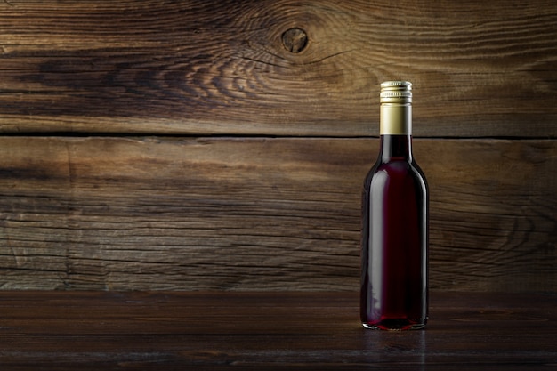 Une bouteille de vin rouge sur un fond en bois