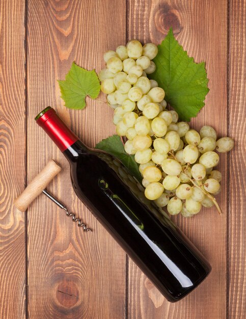 Bouteille de vin rouge et grappe de raisin blanc