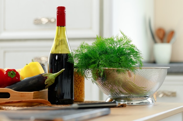 Bouteille de vin rouge et légumes frais sur table de cuisine